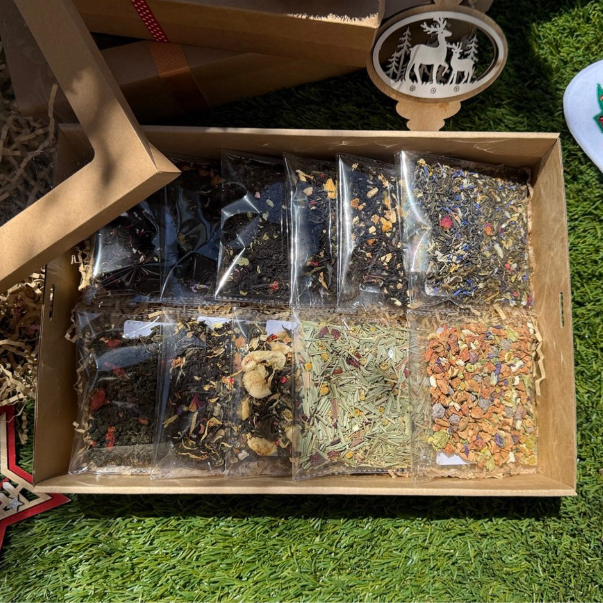 Box of various types of tea bags on a grassy surface
